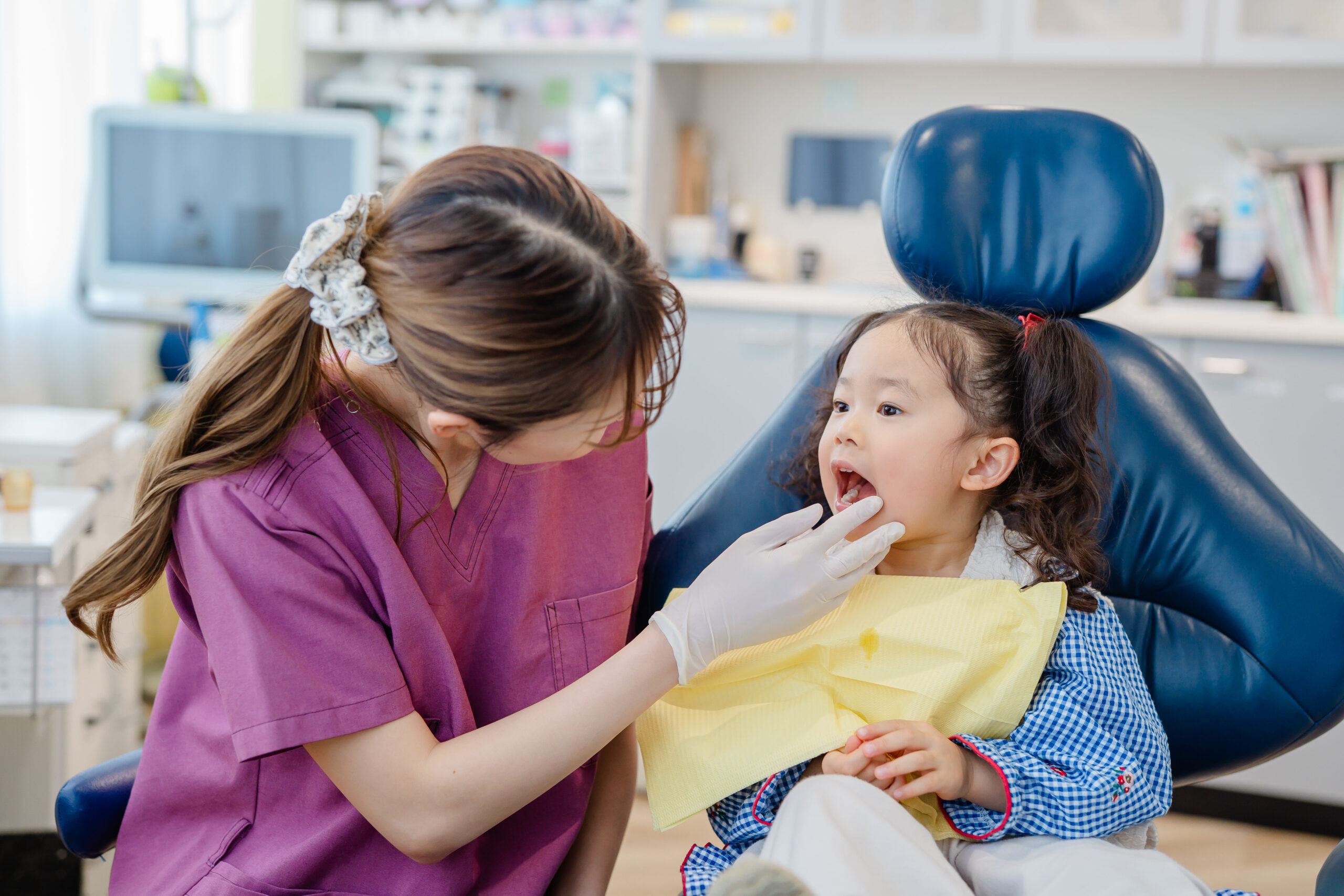 こどものお口の中をチェックする歯科衛生士