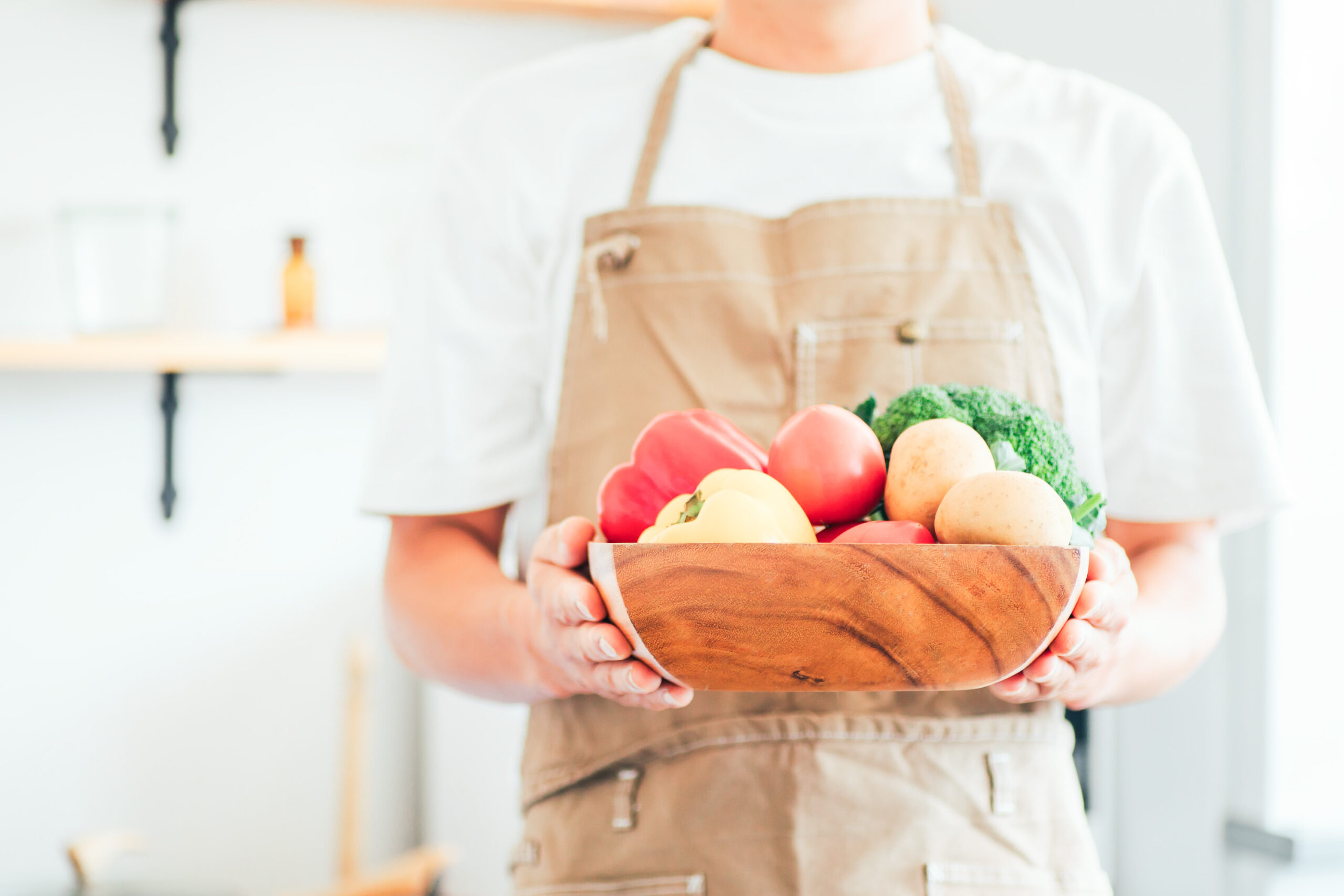 ボールに入った野菜を持つ人